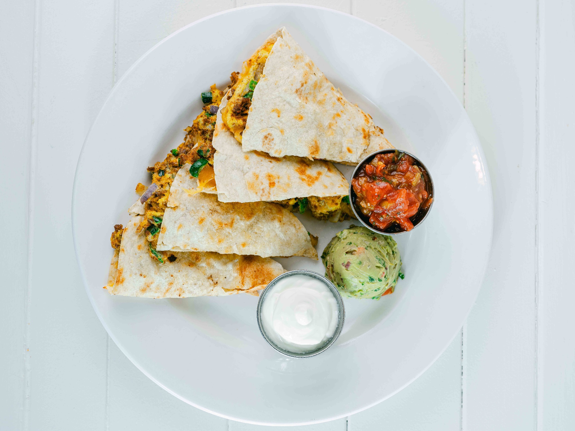 Chorizo breakfast quesadilla with salsa, guac and sour cream