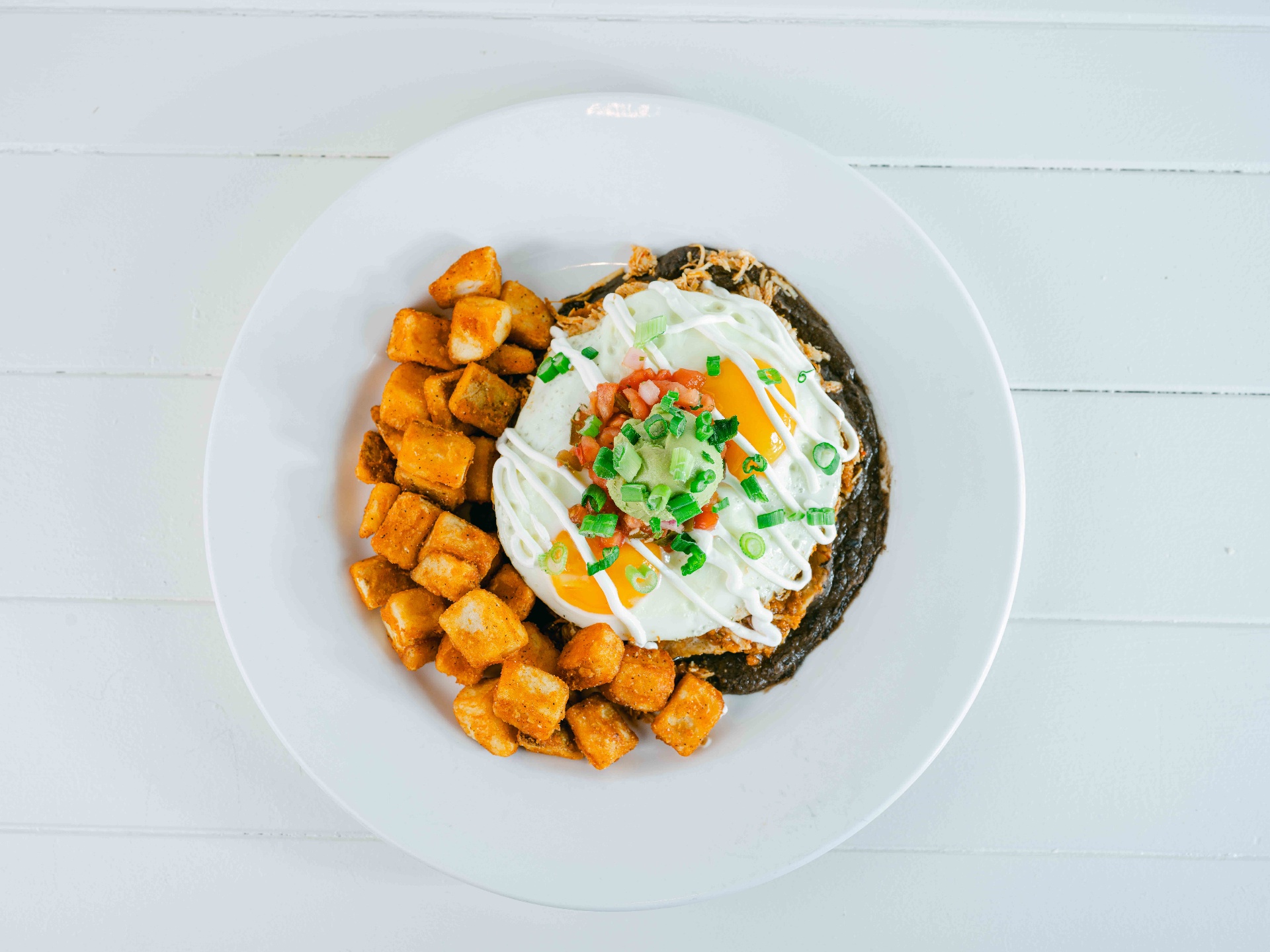 Huevos rancheros over black beans with crispy breakfast potatoes