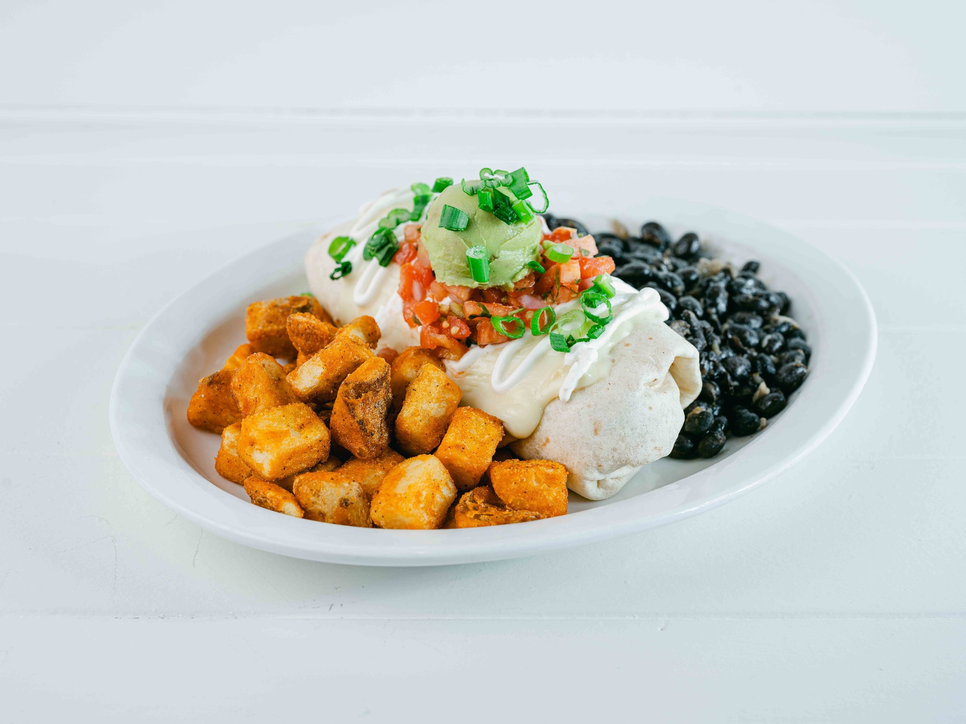 Loaded breakfast burrito with black beans, potatoes and avocado